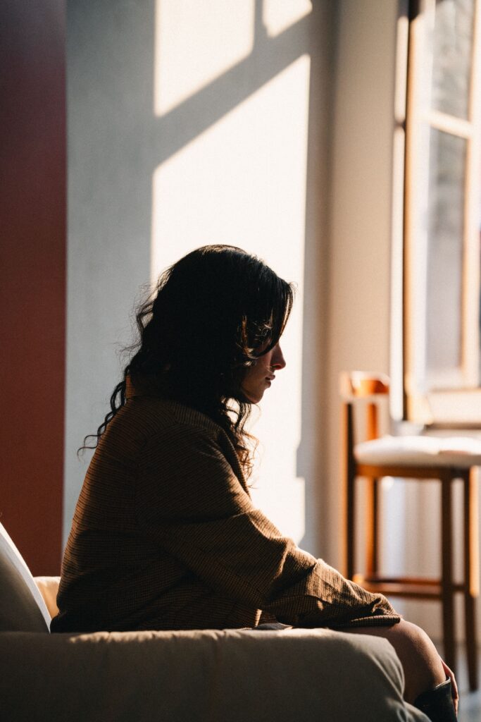 Una mujer sola en una habitación, espacio vacío alrededor.